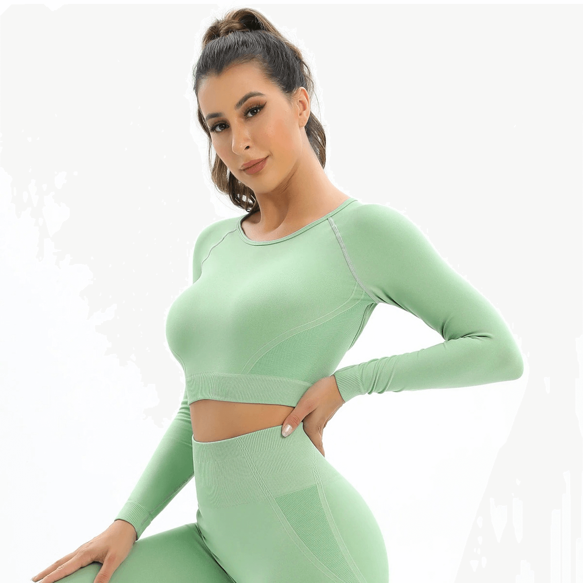 Woman wearing green seamless women's open back long sleeve yoga crop top, showcases fitted design and stylish ventilation.